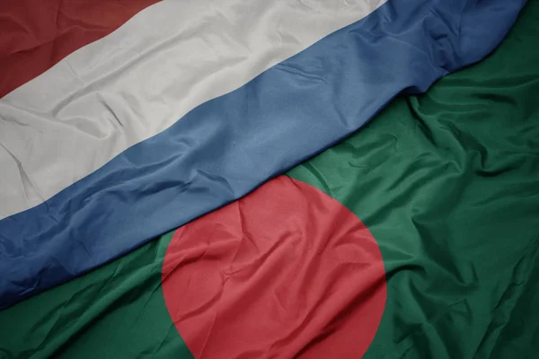 Sventolando bandiera colorata del bangladesh e bandiera nazionale di luxembourg . — Foto Stock