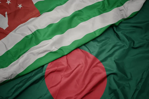 Sventolando bandiera colorata del bangladesh e bandiera nazionale dell'abkhazia . — Foto Stock