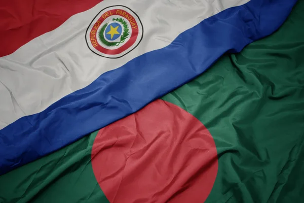 Sventolando bandiera colorata del bangladesh e bandiera nazionale del paraguay . — Foto Stock