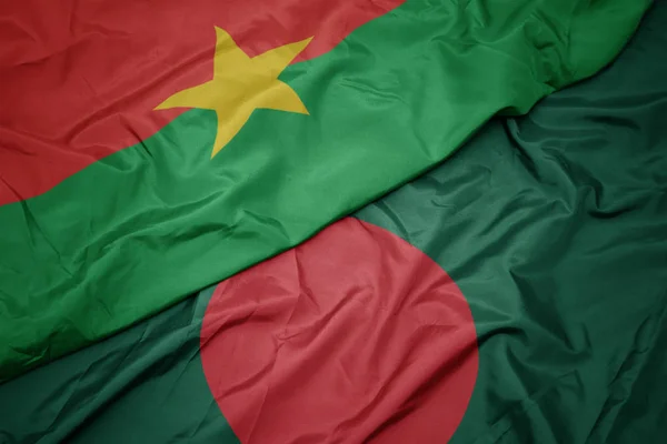 Ondeando colorida bandera de bangladesh y bandera nacional de burkina faso . — Foto de Stock