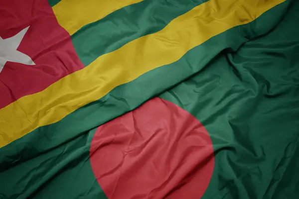 Schwenken bunte Flagge von Bangladesh und Nationalflagge von Togo. — Stockfoto