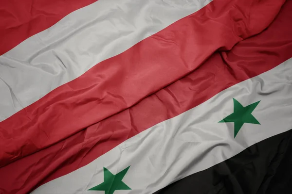 Sventolando bandiera colorata di syria e bandiera nazionale di austria . — Foto Stock