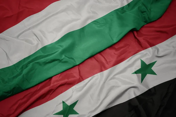 Sventolando bandiera colorata della Siria e bandiera nazionale dell'Ungheria . — Foto Stock