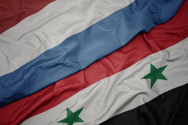 Sventolando bandiera colorata della Siria e bandiera nazionale di Lussemburgo . — Foto Stock