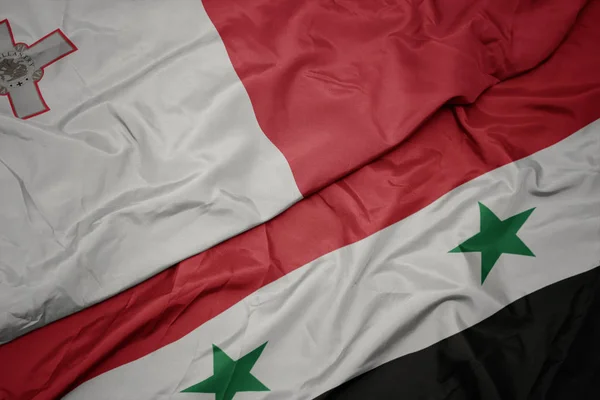 Ondeando colorida bandera de Siria y bandera nacional de Malta . —  Fotos de Stock