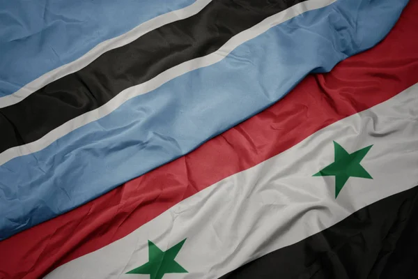 Sventolando bandiera colorata della Siria e bandiera nazionale del Botswana . — Foto Stock