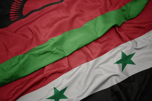 Ondeando colorida bandera de Siria y bandera nacional de Malawi . —  Fotos de Stock