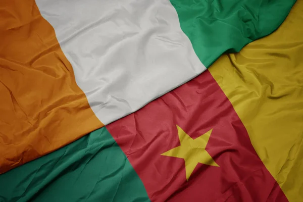 Ondeando colorida bandera de camerún y bandera nacional de cote divoire . —  Fotos de Stock