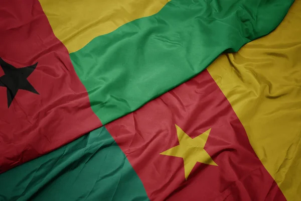 Ondeando colorida bandera de camerún y bandera nacional de Guinea Bissau . —  Fotos de Stock