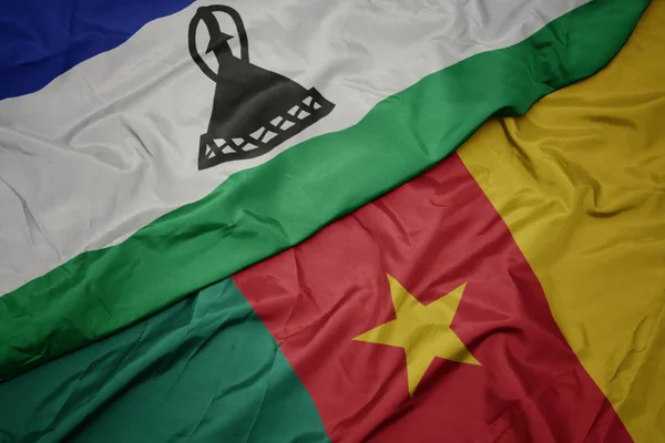 Ondeando colorida bandera de camerún y bandera nacional de lesoto . — Foto de Stock