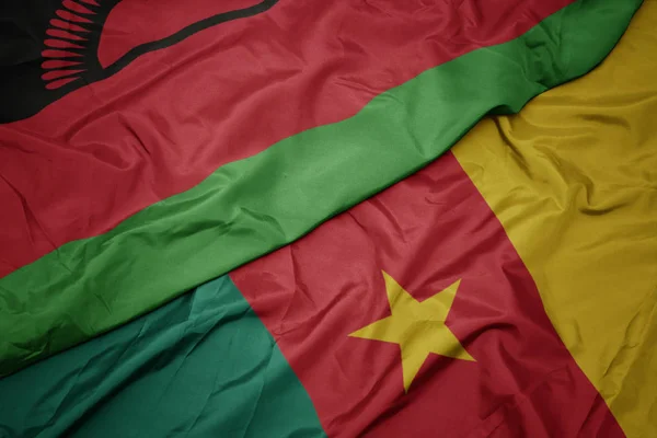 Ondeando colorida bandera de camerún y bandera nacional de malawi . — Foto de Stock