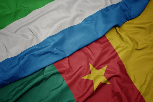 Ondeando colorida bandera de camerún y bandera nacional de Sierra Leona . — Foto de Stock