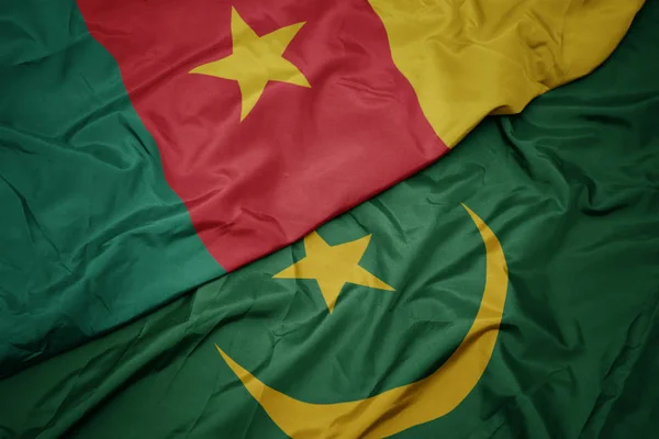 Ondeando colorida bandera de Mauritania y bandera nacional de camerún . — Foto de Stock