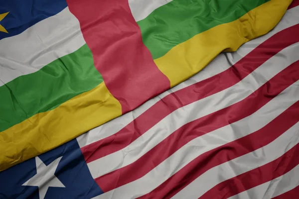Acenando bandeira colorida da Libéria e bandeira nacional da República Centro-Africana . — Fotografia de Stock