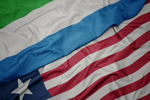 Mávání barevnou vlajkou liberie a národní vlajky Sierra Leone. — Stock fotografie