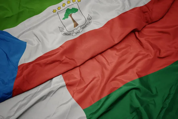 Zwaaiende vlag van madagascar en nationale vlag van equatoriale guinea. — Stockfoto
