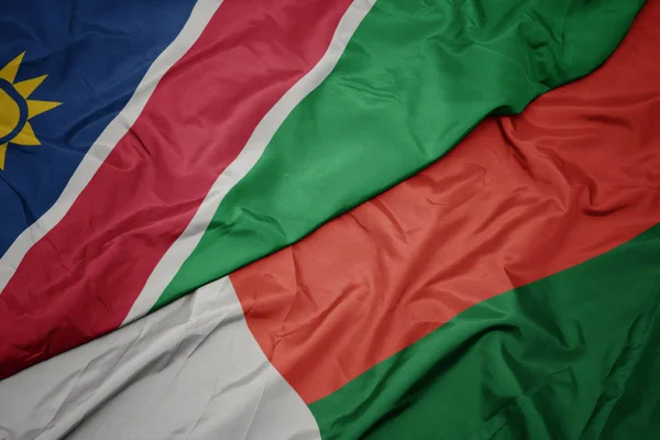 Machanie barwną flagą Madagaskaru i flagą narodową Namibii. — Zdjęcie stockowe