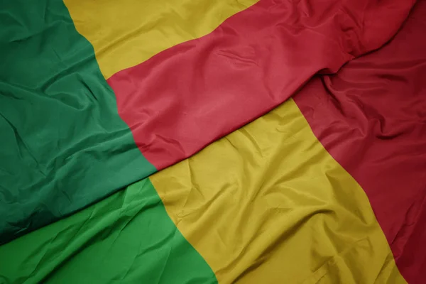 Zwaaiende kleurrijke vlag van mali en nationale vlag van benin. — Stockfoto