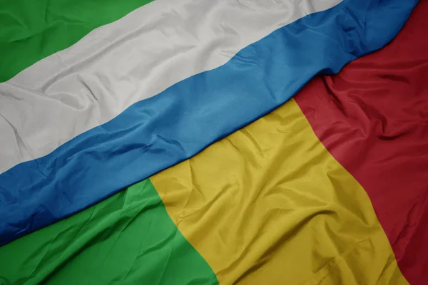 Machając barwną flagą mali i flagą narodową Sierra Leone. — Zdjęcie stockowe