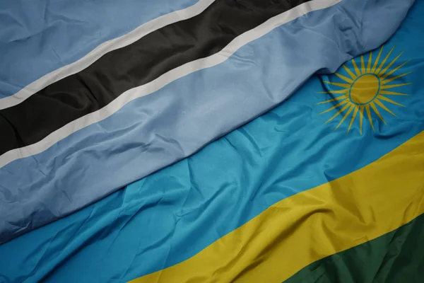 Ondeando colorida bandera de Ruanda y bandera nacional de botswana . —  Fotos de Stock