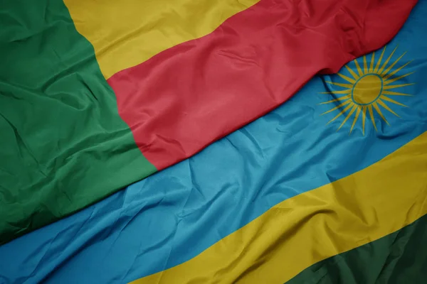 Размахивая красочным флагом Руанды и национальным флагом Бенина . — стоковое фото