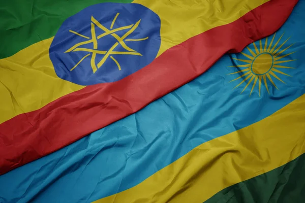 Machanie kolorową flagą Rwandy i narodową flagą Etiopii . — Zdjęcie stockowe