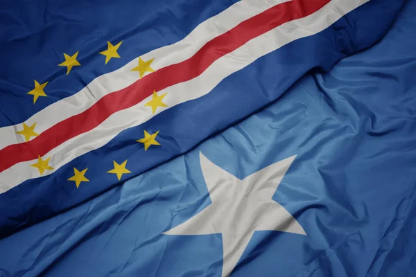 Mávání barevnou vlajkou Somálska a národní vlajky Cape Verde. — Stock fotografie