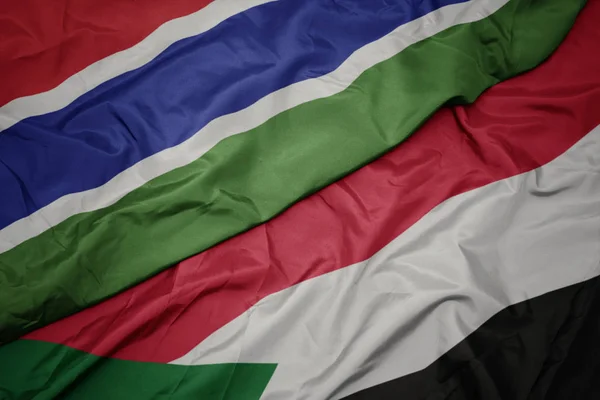 Waving colorful flag of sudan and national flag of gambia. — Stock Photo, Image