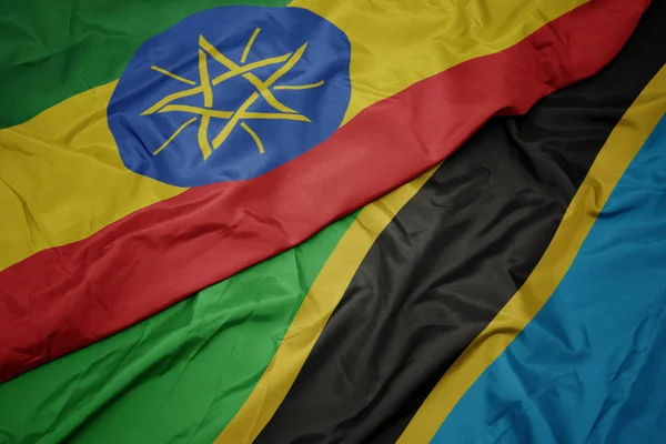 Machanie kolorową flagą Tanzanii i narodową flagą Etiopii . — Zdjęcie stockowe