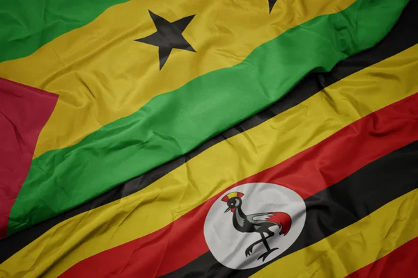 Размахивая красочным флагом Уганды и национальным флагом Сан-Томе и принципиальным  . — стоковое фото