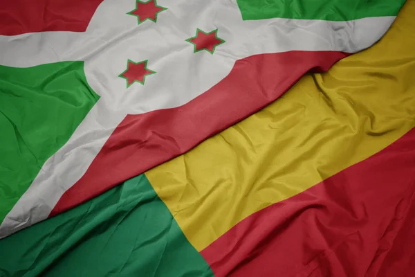 Ondeando colorida bandera de benin y bandera nacional de burundi  . — Foto de Stock