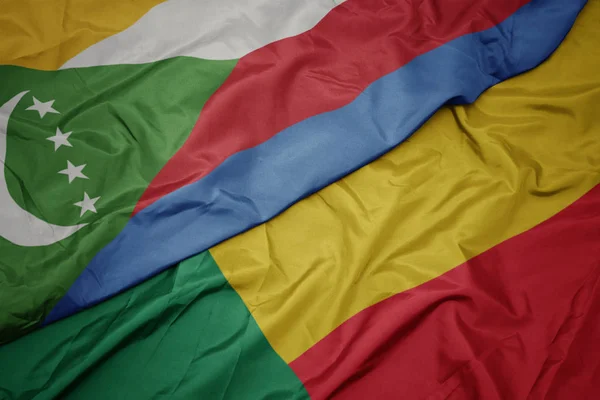 Waving colorful flag of benin and national flag of comoros. — Stock Photo, Image
