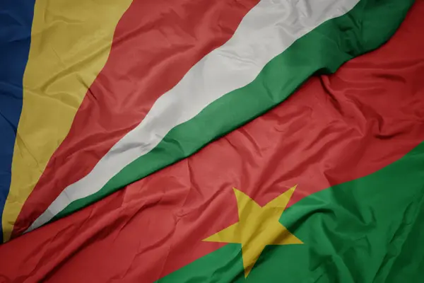 Waving colorful flag of burkina faso and national flag of seychelles. — Stok fotoğraf