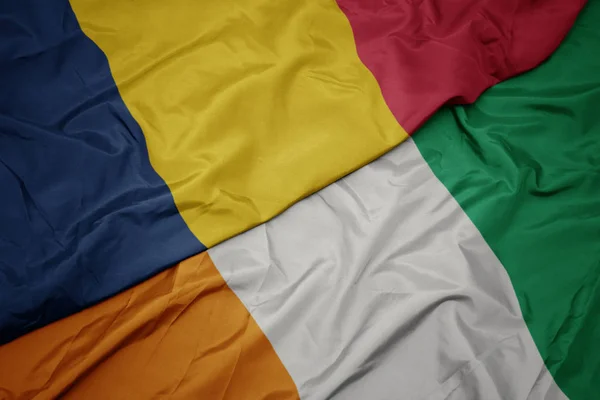 Machanie barwną flagą cote divoire i flagą narodową chad. — Zdjęcie stockowe