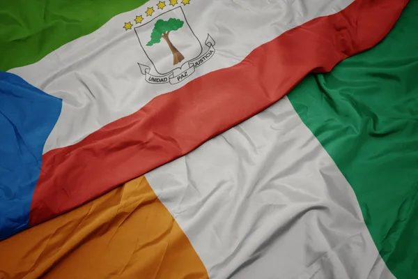 Ondeando colorida bandera de cote divoire y bandera nacional de guinea ecuatorial . —  Fotos de Stock