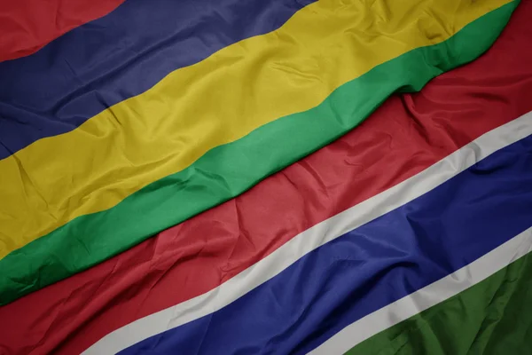 Agitant drapeau coloré de la gambie et drapeau national de mauritius . — Photo