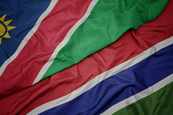 Acenando bandeira colorida da gâmbia e bandeira nacional da namíbia . — Fotografia de Stock