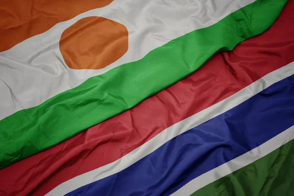 Acenando bandeira colorida de gâmbia e bandeira nacional de niger . — Fotografia de Stock