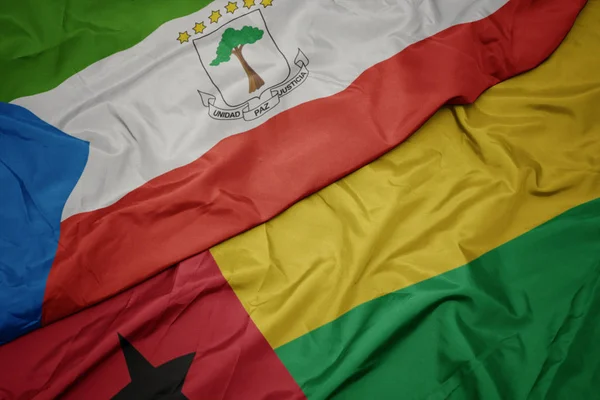 Ondeando colorida bandera de Guinea Bissau y bandera nacional de Guinea Ecuatorial . —  Fotos de Stock