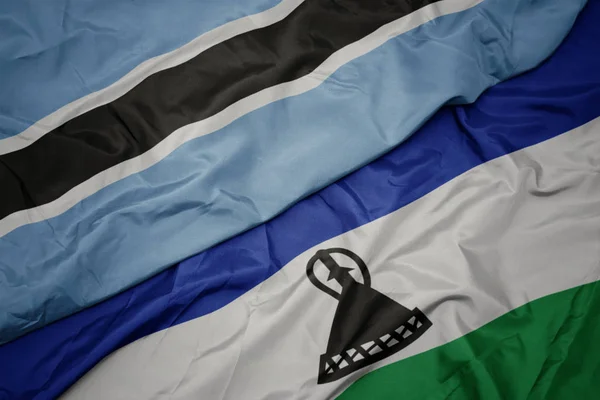 Agitant drapeau coloré du Lesotho et drapeau national du Botswana . — Photo
