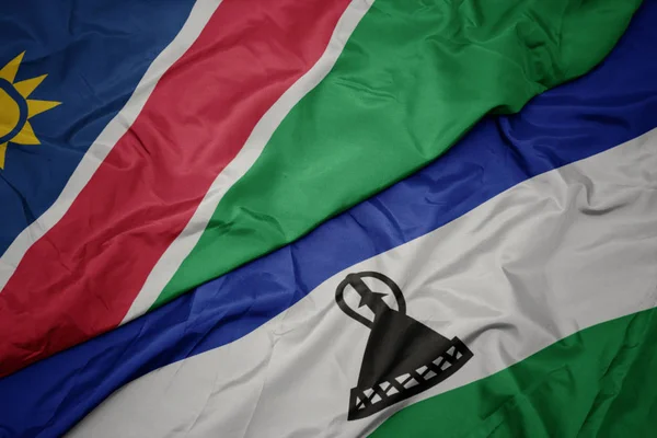 Viftande färgglada flagga lesotho och nationell flagga namibia. — Stockfoto