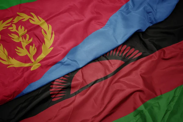 Agitant drapeau coloré de malawi et drapeau national de l'eritrea . — Photo