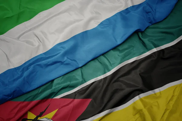 Acenando bandeira colorida de moçambique e bandeira nacional de sierra leone . — Fotografia de Stock