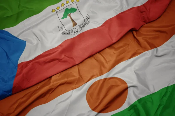 Sventolando bandiera colorata di niger e bandiera nazionale di ghinea equatoriale . — Foto Stock