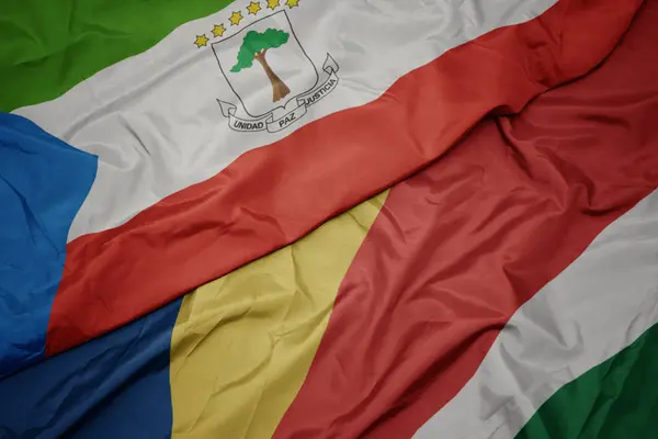 Ondeando colorida bandera de seychelles y bandera nacional de guinea ecuatorial . —  Fotos de Stock