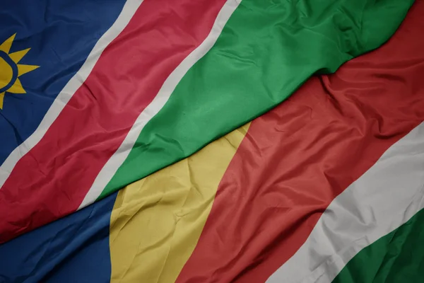 Acenando bandeira colorida de seicheles e bandeira nacional da Namíbia . — Fotografia de Stock