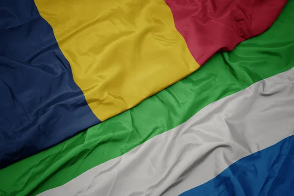 Ondeando colorida bandera de Sierra Leona y bandera nacional de Chad . — Foto de Stock