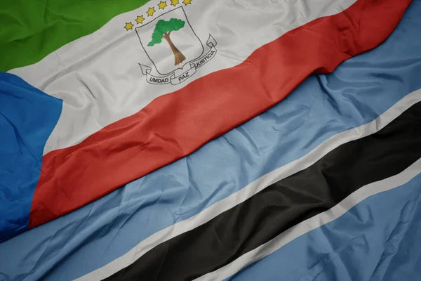 Ondeando colorida bandera de botswana y bandera nacional de guinea ecuatorial . —  Fotos de Stock