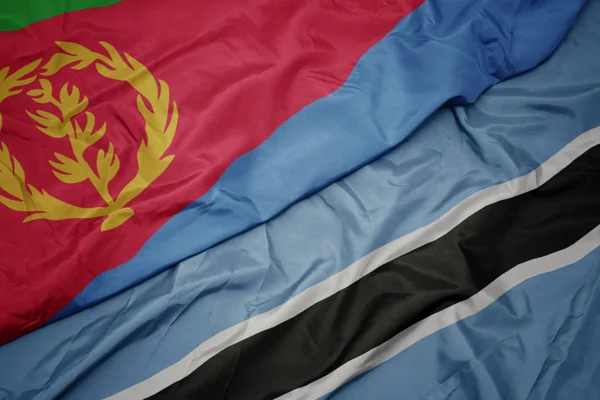 Agitant le drapeau coloré du Botswana et le drapeau national de l'éritrée . — Photo