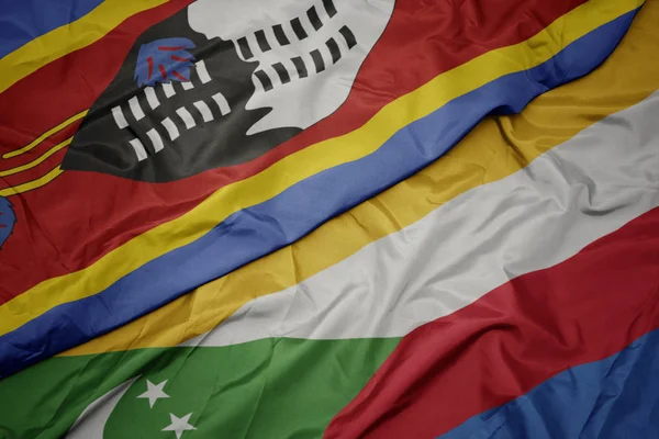 Acenando bandeira colorida de comorbios e bandeira nacional da Suazilândia . — Fotografia de Stock